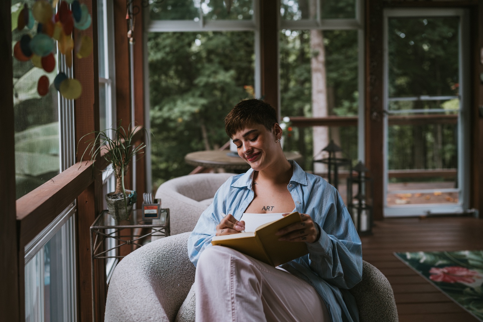 Rylee writing in a notebook beside a window